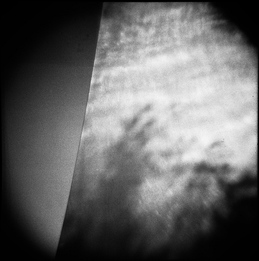Shadows of a tree on metal against a clear, blue sky